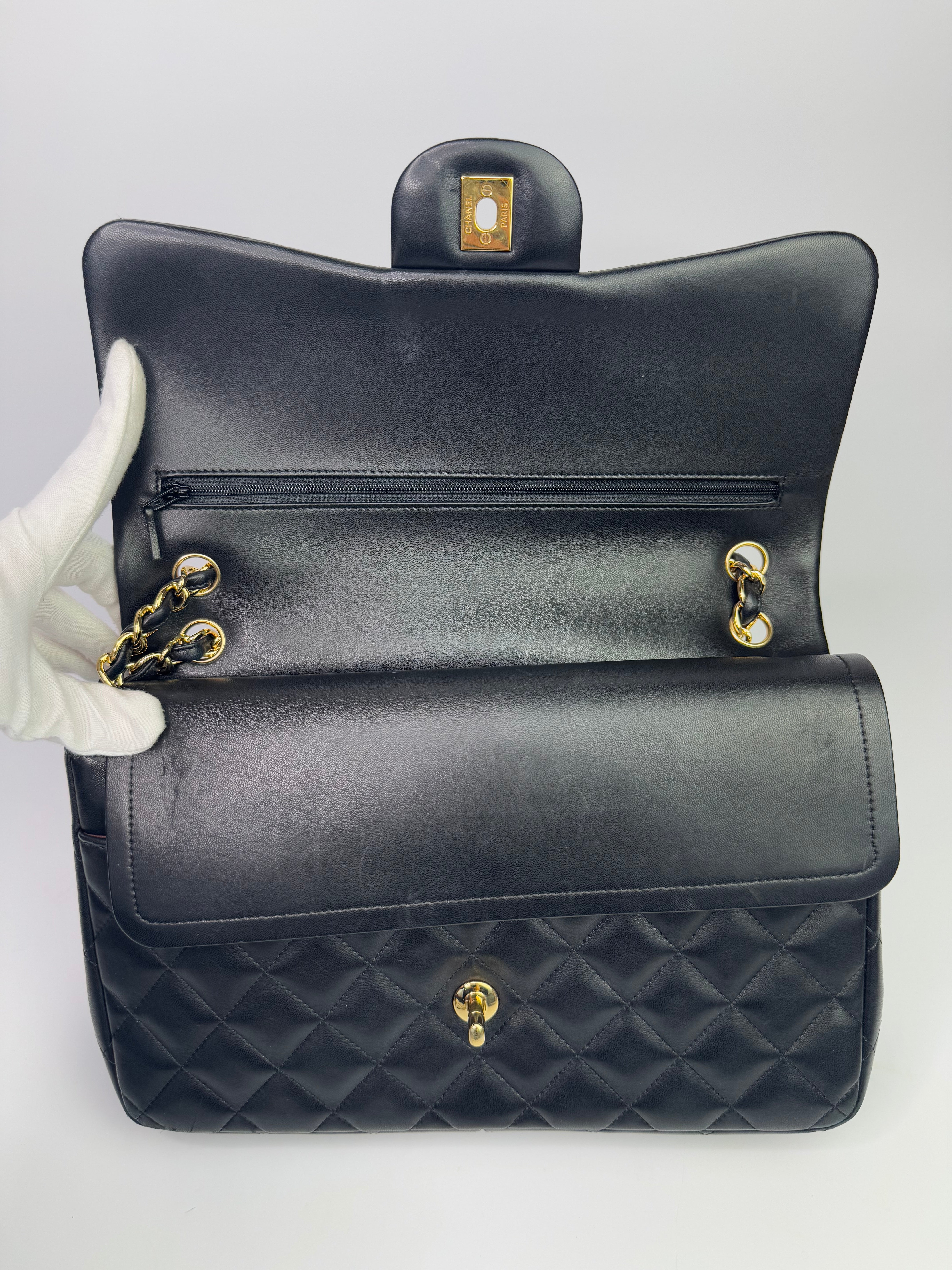 Authentic pre-loved Chanel Black Lambskin Leather Jumbo Classic Double Flap With Gold Hardware.