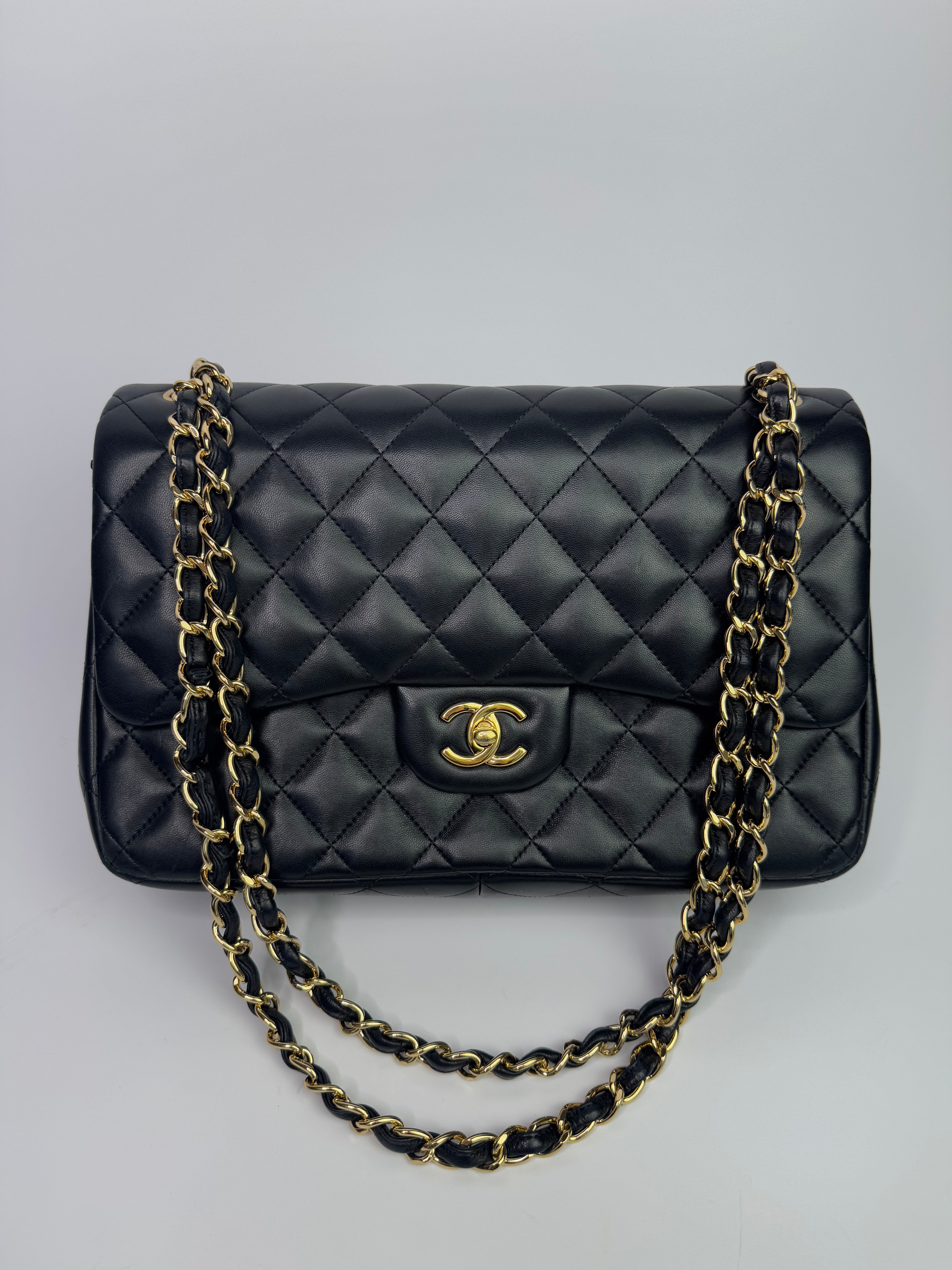 Authentic pre-loved Chanel Black Lambskin Leather Jumbo Classic Double Flap With Gold Hardware.