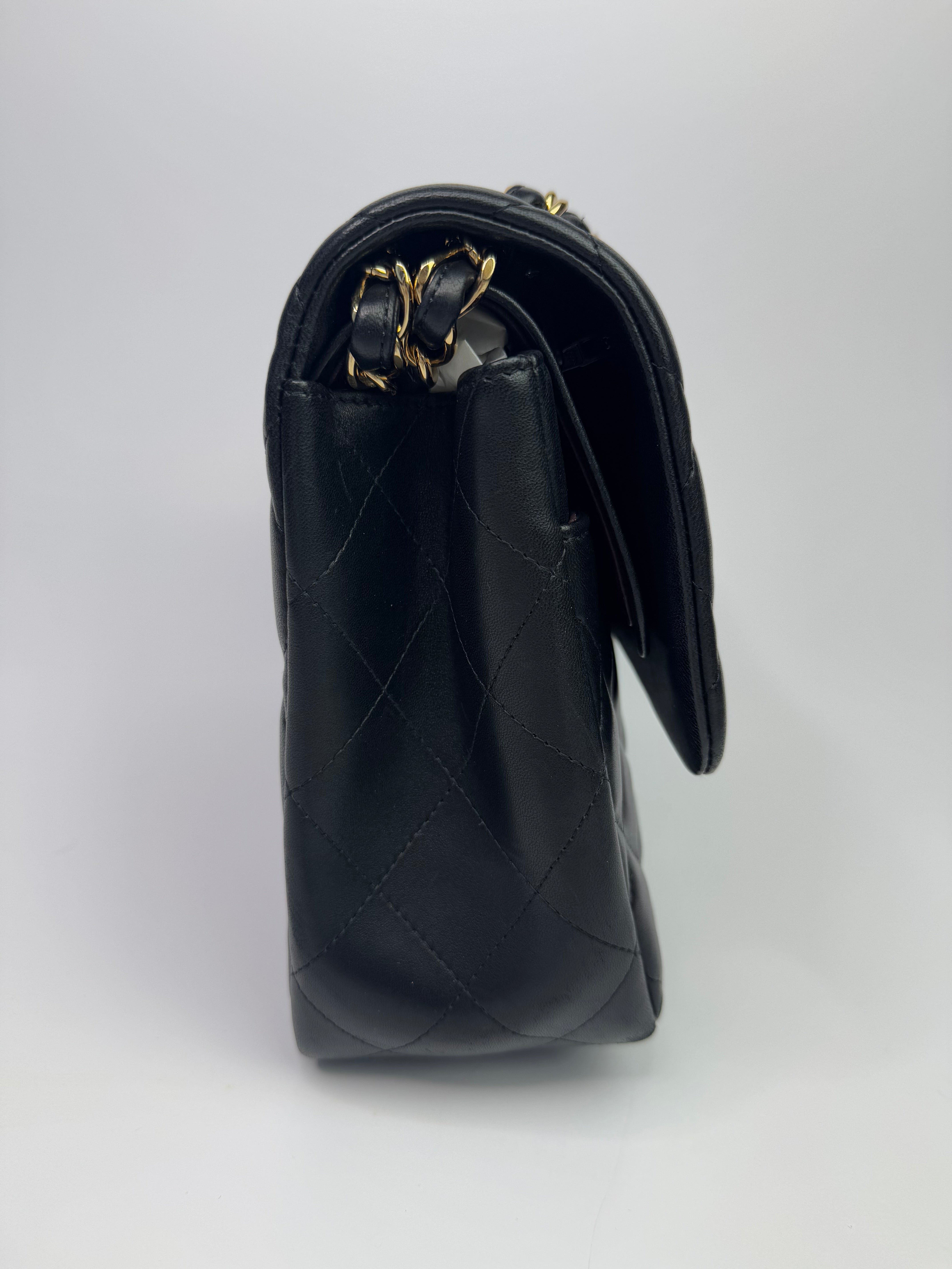 Authentic pre-loved Chanel Black Lambskin Leather Jumbo Classic Double Flap With Gold Hardware.