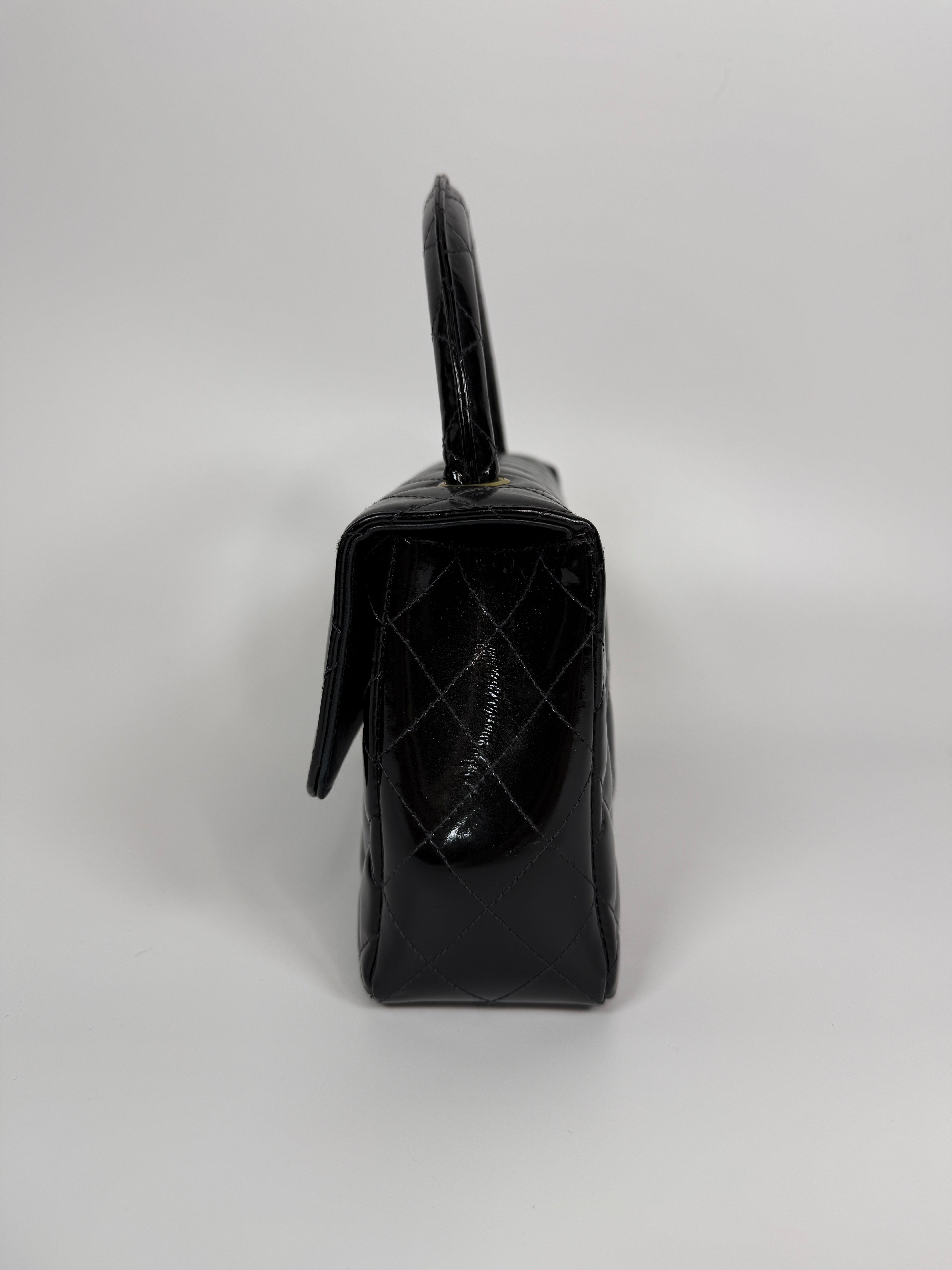 Authentic and preloved Chanel Vintage Kelly Top Handle Bag In Black Patent Leather With 24kt Gold Hardware. Very Good condition. 100% Authenticity guarantee