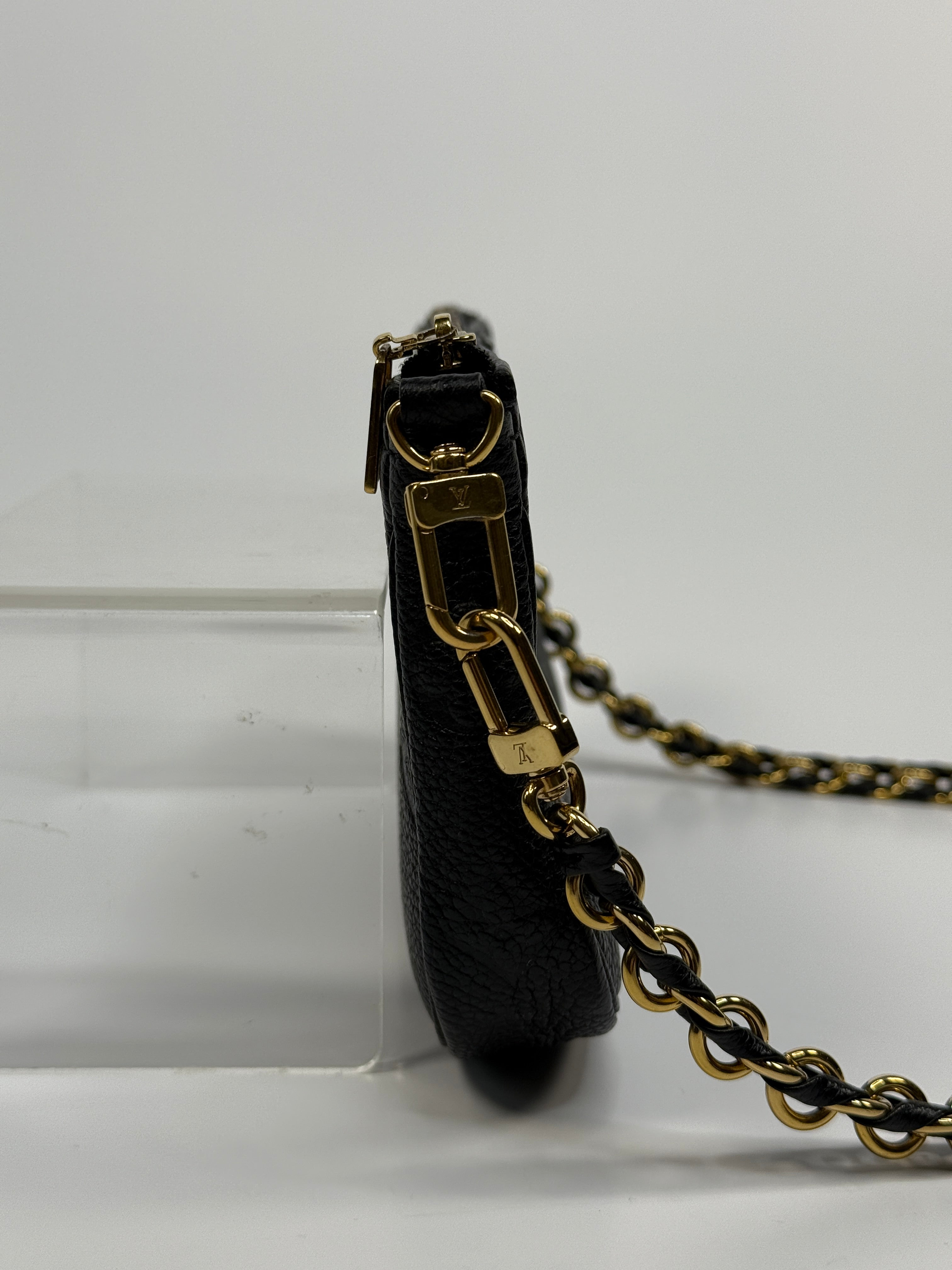 Black leather belt with gold hardware on a white background