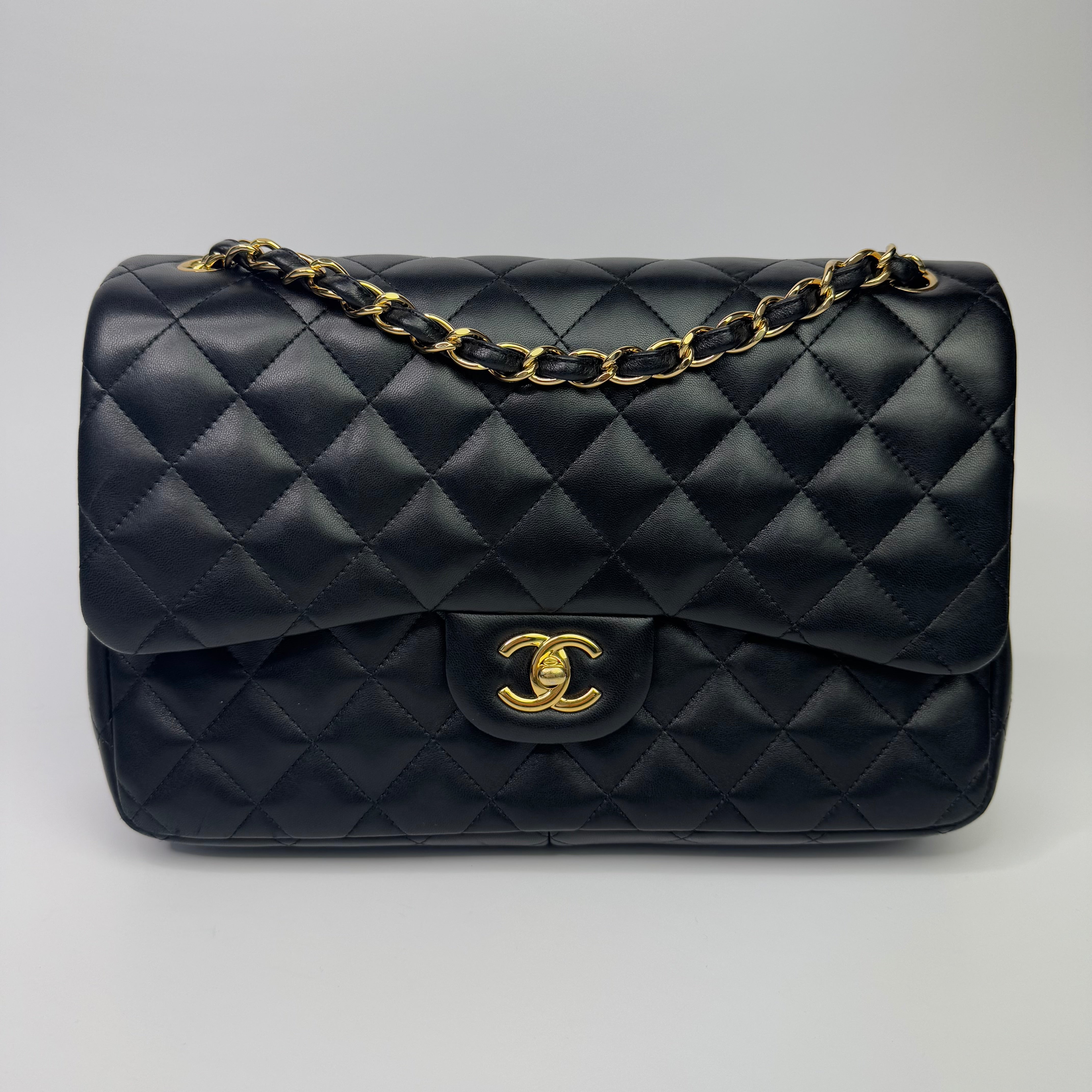 Authentic pre-loved Chanel Black Lambskin Leather Jumbo Classic Double Flap With Gold Hardware.