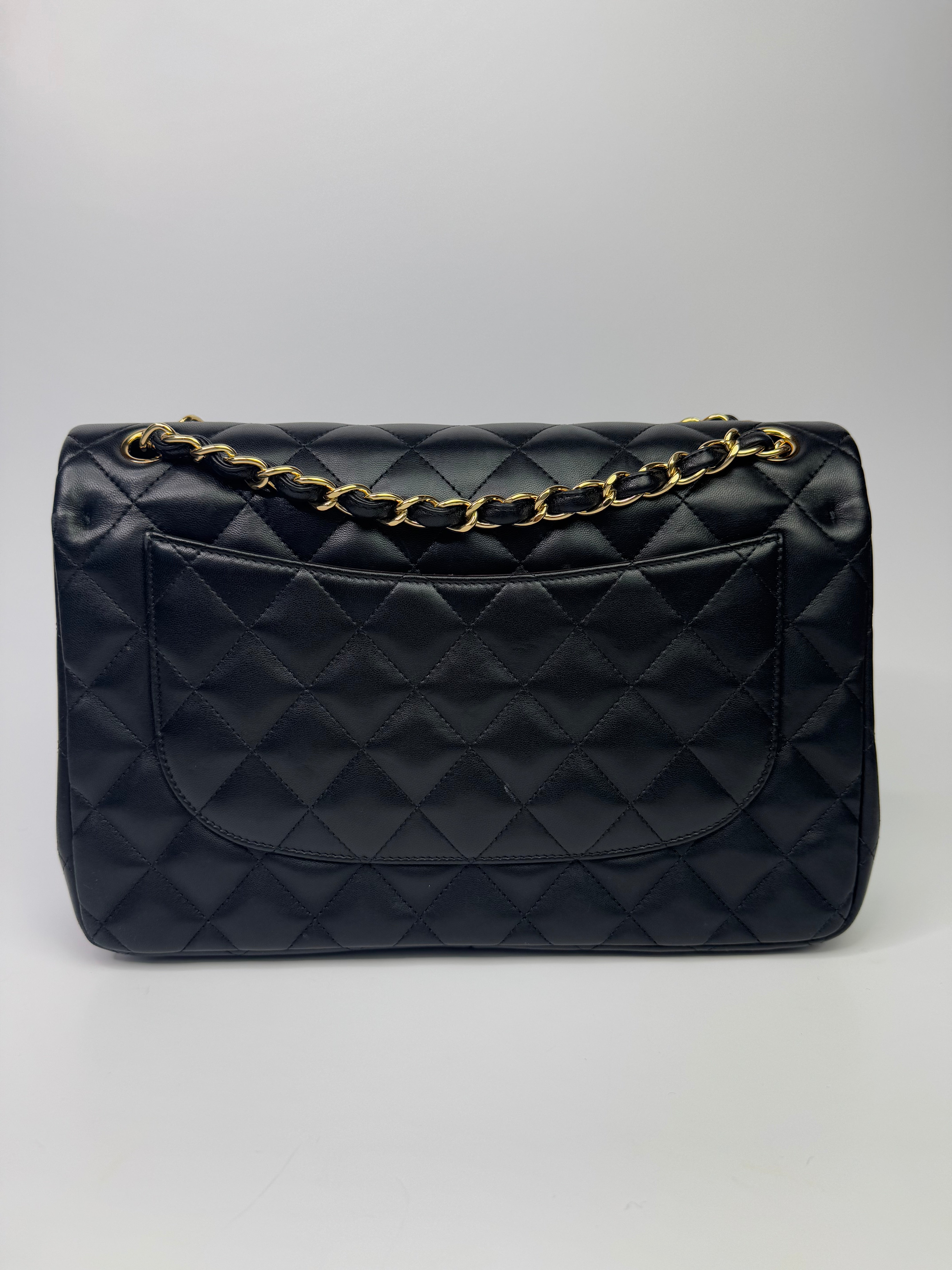 Authentic pre-loved Chanel Black Lambskin Leather Jumbo Classic Double Flap With Gold Hardware.