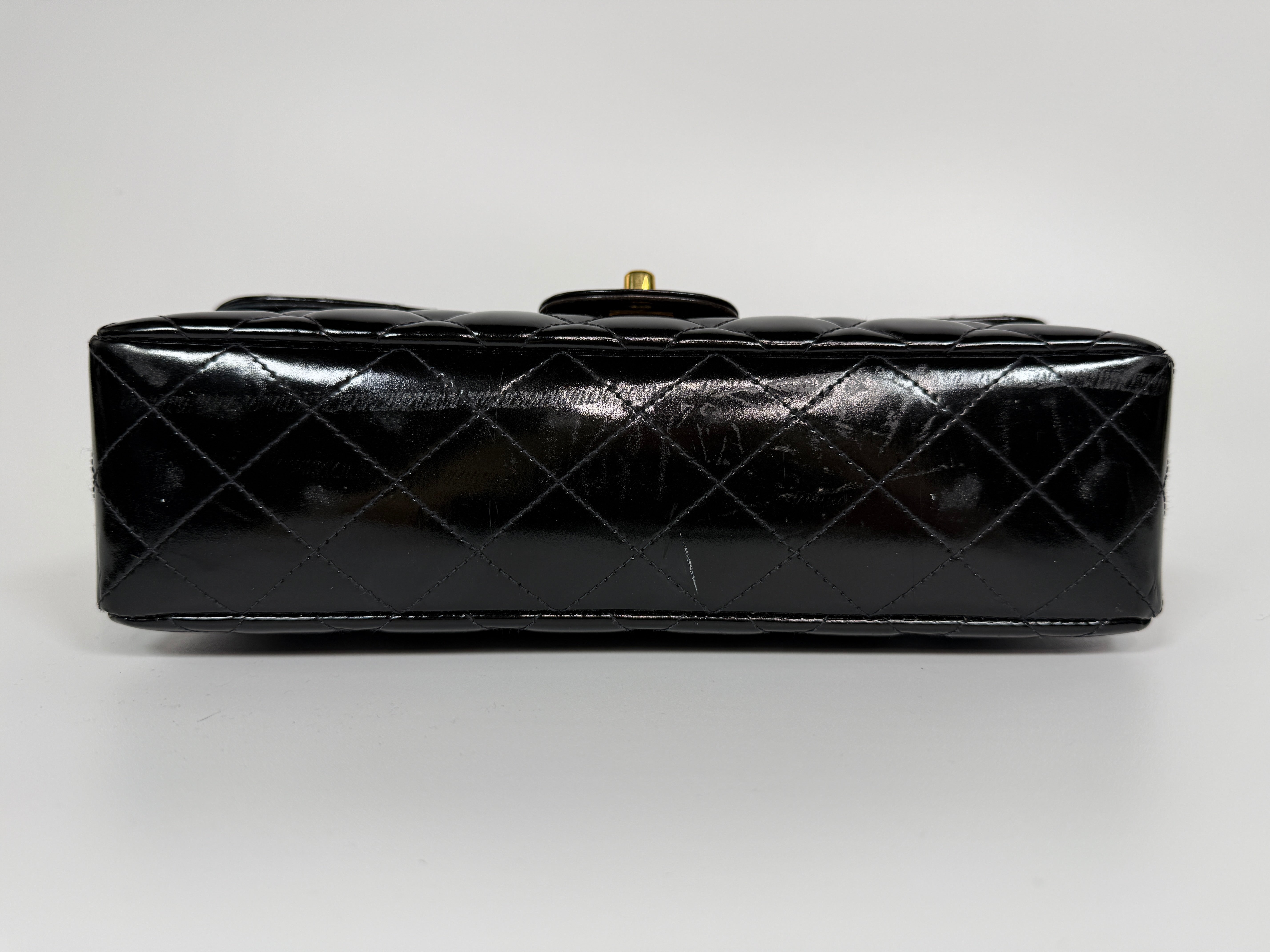 Authentic and preloved Chanel Vintage Kelly Top Handle Bag In Black Patent Leather With 24kt Gold Hardware. Very Good condition. 100% Authenticity guarantee