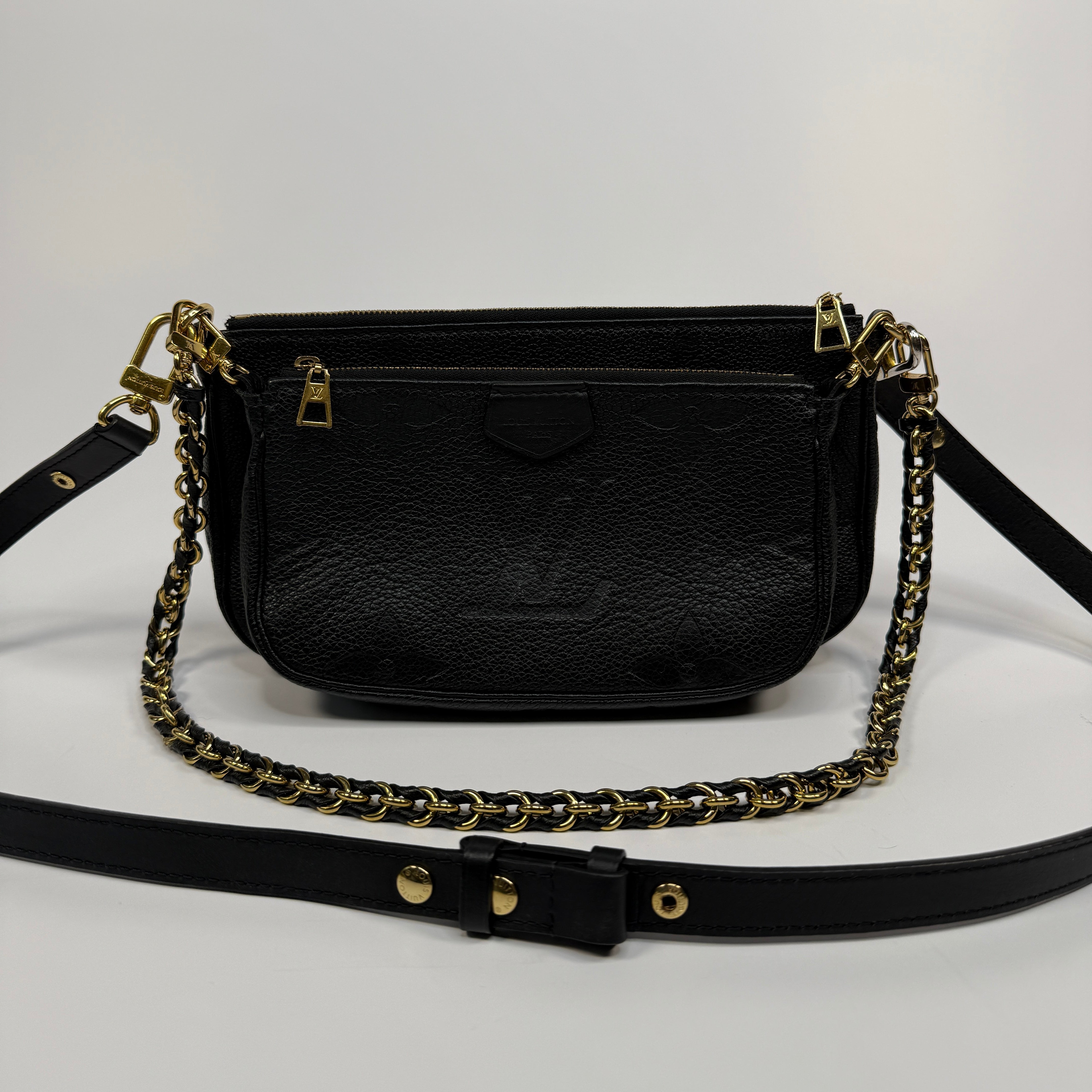 Black handbag with gold chain strap on a white background