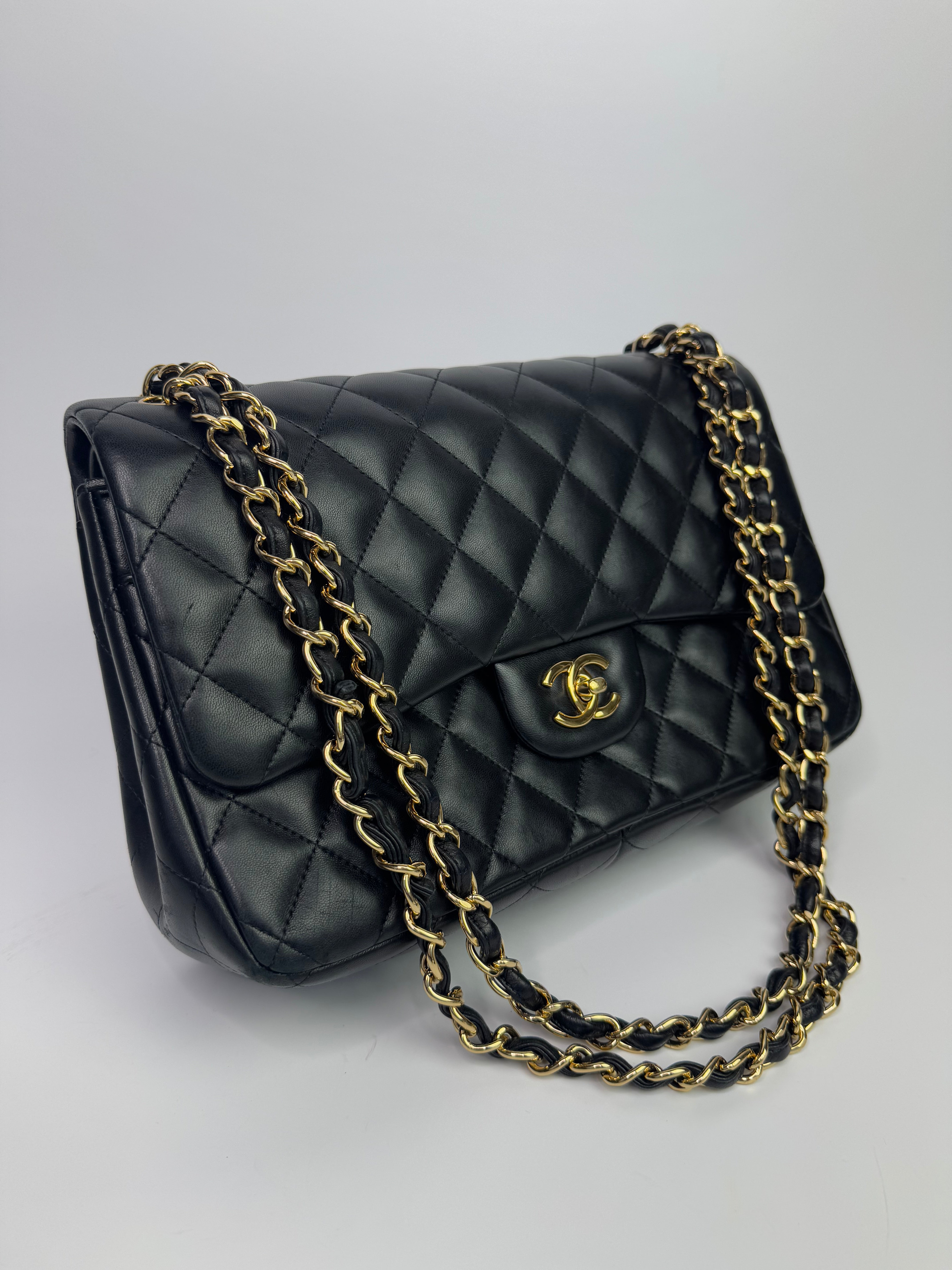 Authentic pre-loved Chanel Black Lambskin Leather Jumbo Classic Double Flap With Gold Hardware. 