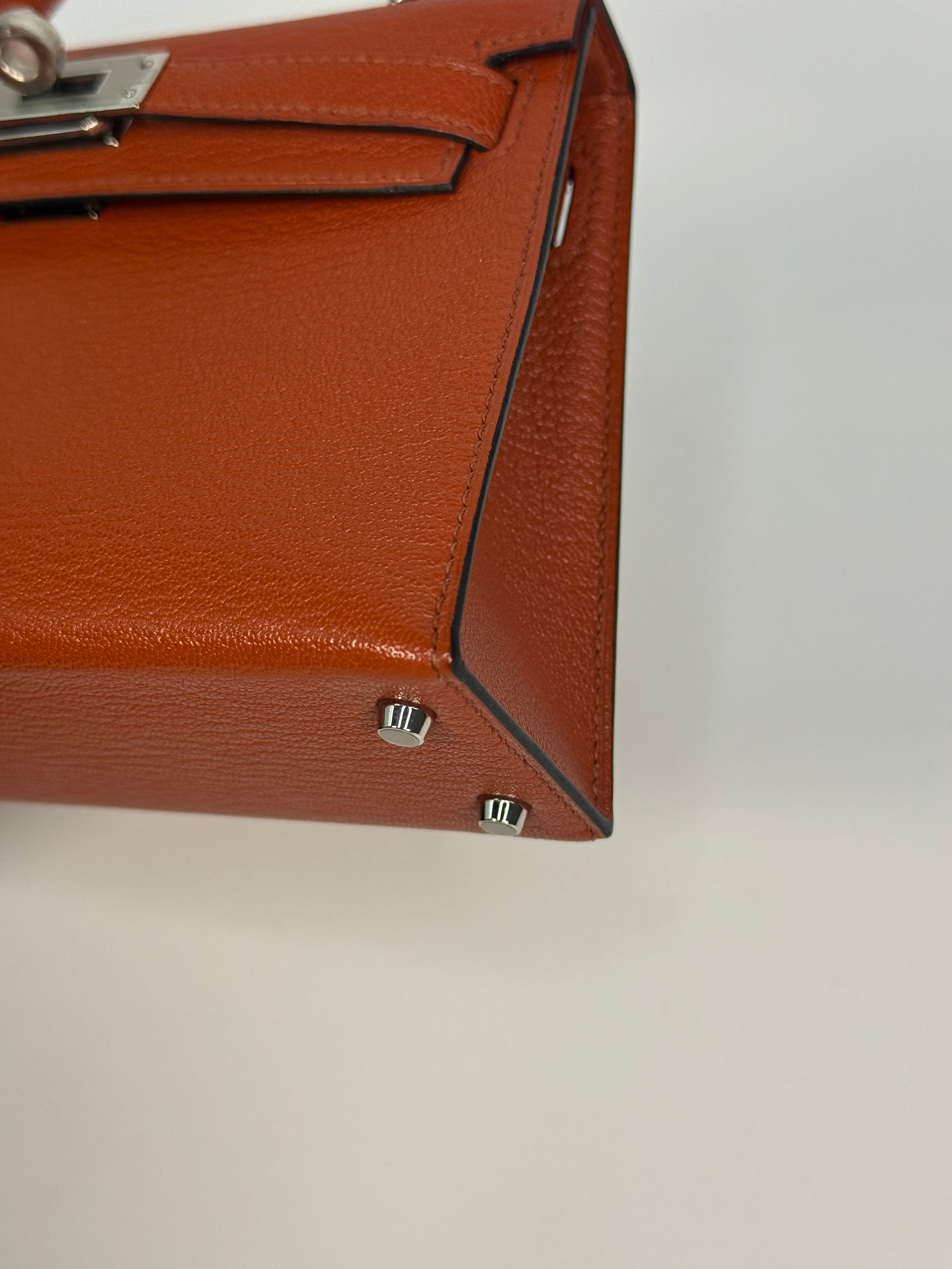 Hermès Mini Kelly In Cuivre Chèvre Mysore Leather With Palladium Hardware. Authentic and preloved in new and unused condition