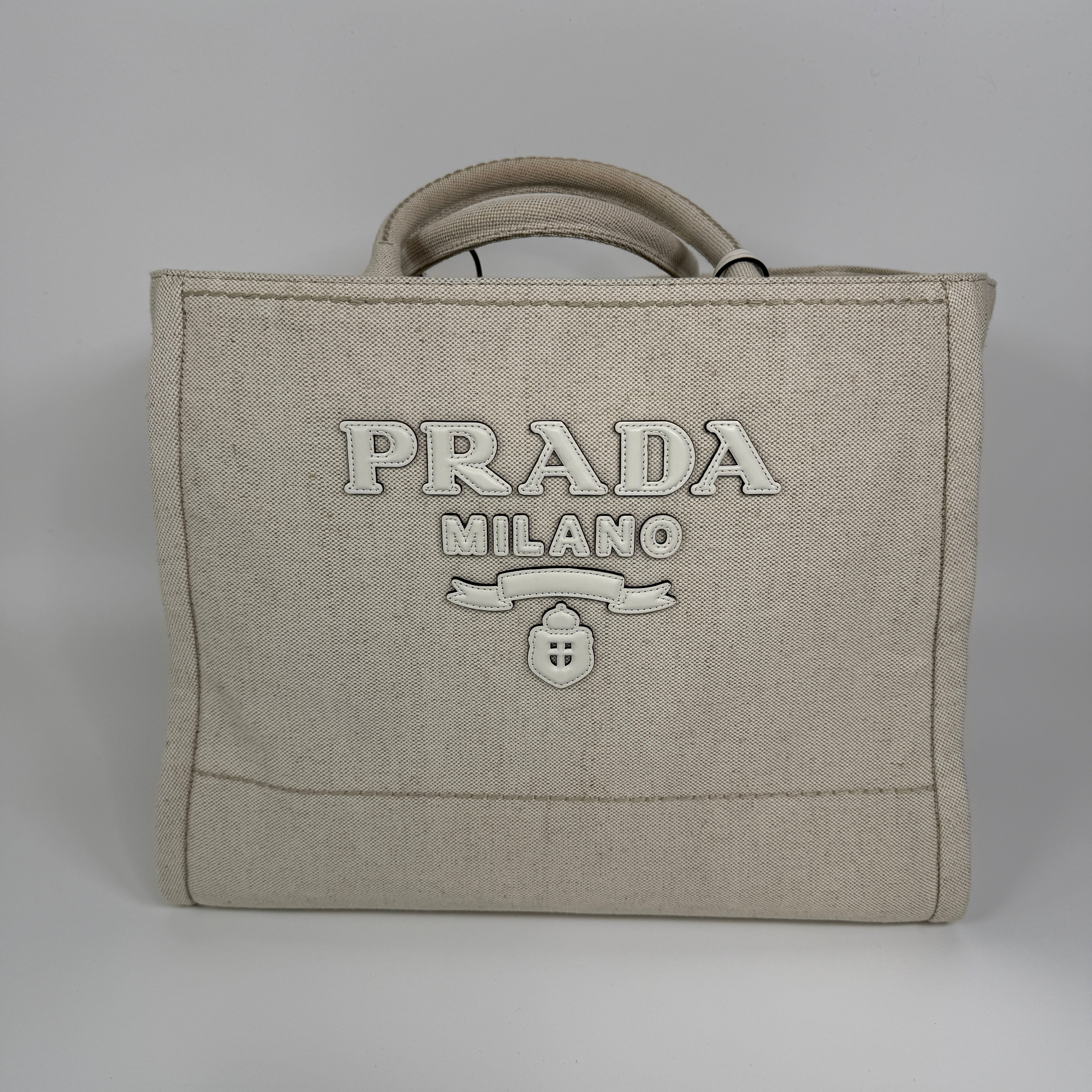 Authentic and preloved Prada Large Appliqué Cotton Tote In Sand Beige Canvas. Excellent Condition. 100% Authenticity guarantee. 