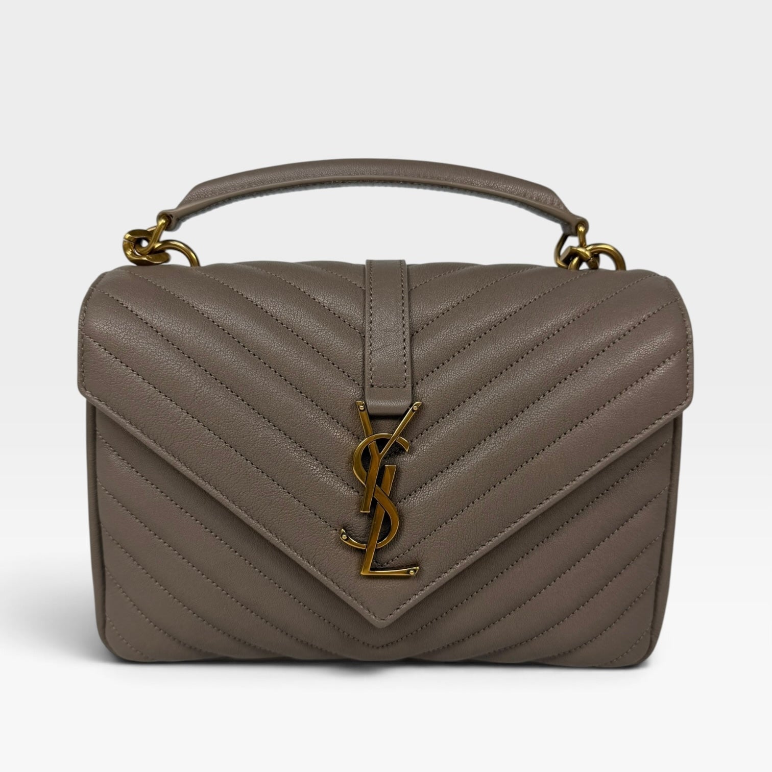 A Saint Laurent top-handle handbag in taupe gray chevron quilted leather with a gold-tone YSL logo clasp on the front flap.