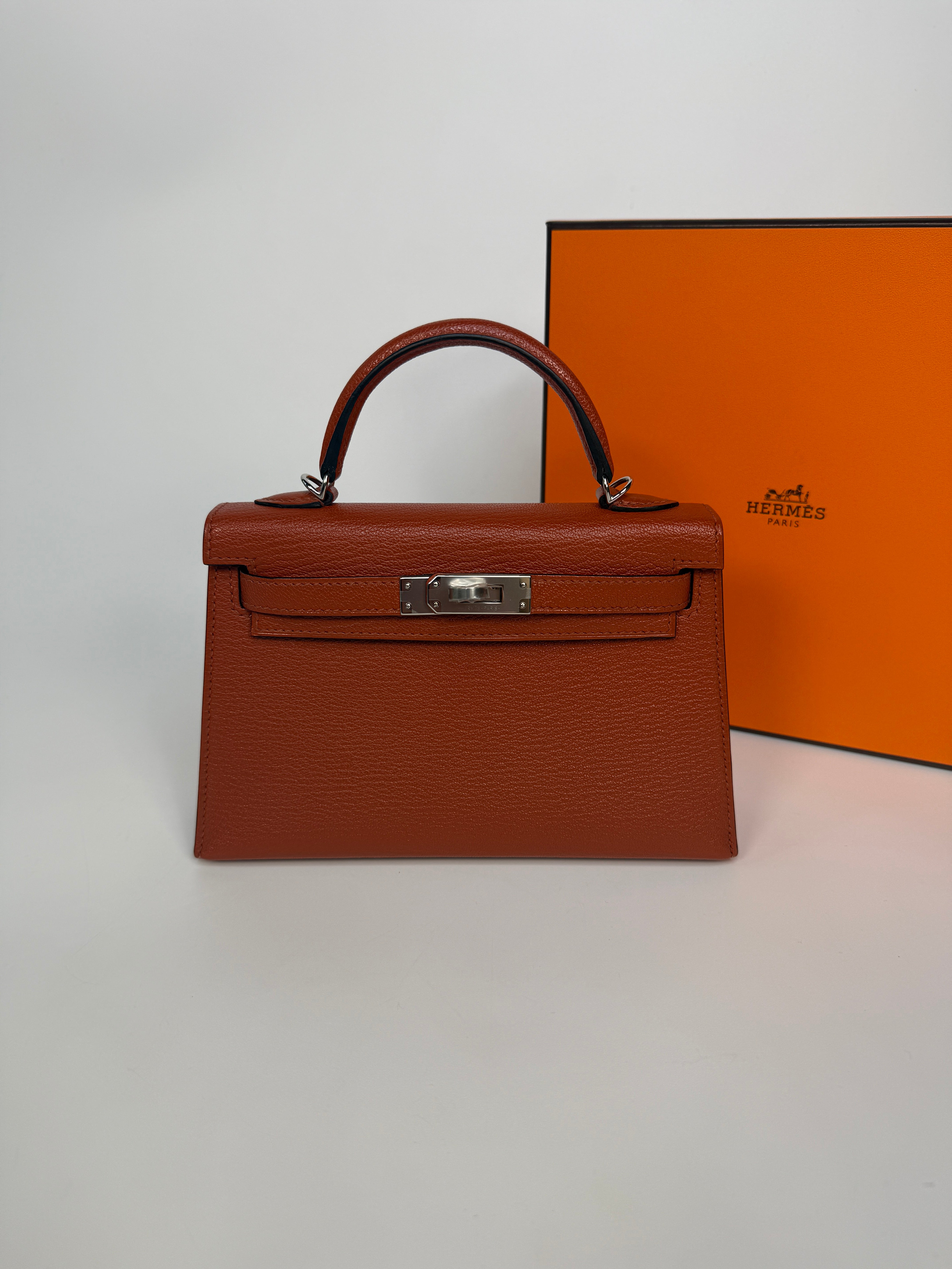 Hermès Mini Kelly In Cuivre Chèvre Mysore Leather With Palladium Hardware. Authentic and preloved in new and unused condition