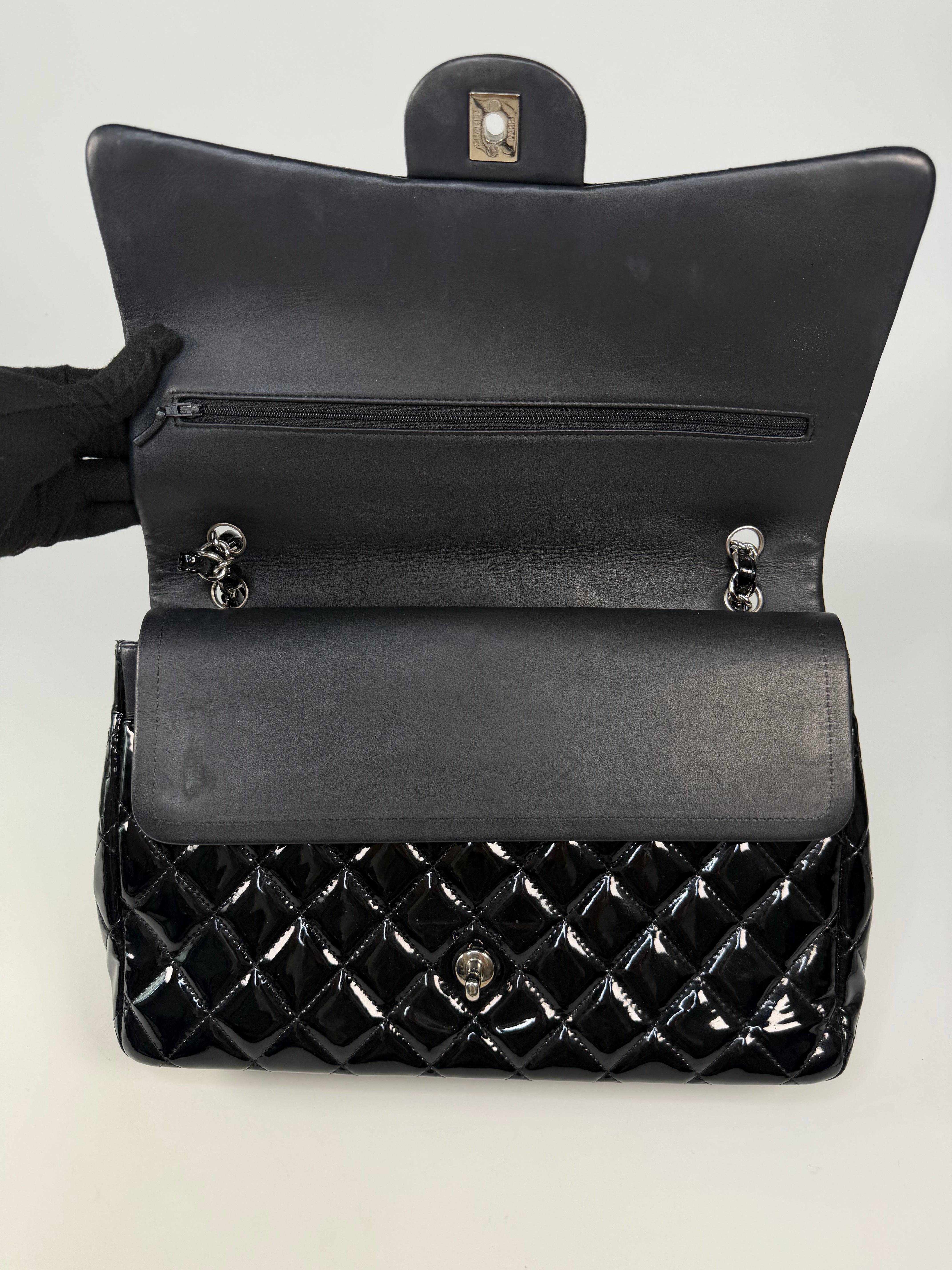 Chanel Maxi Classic Double Flap In Black Patent Leather With Silver Hardware. 100% authentic and preloved in excellent condition.