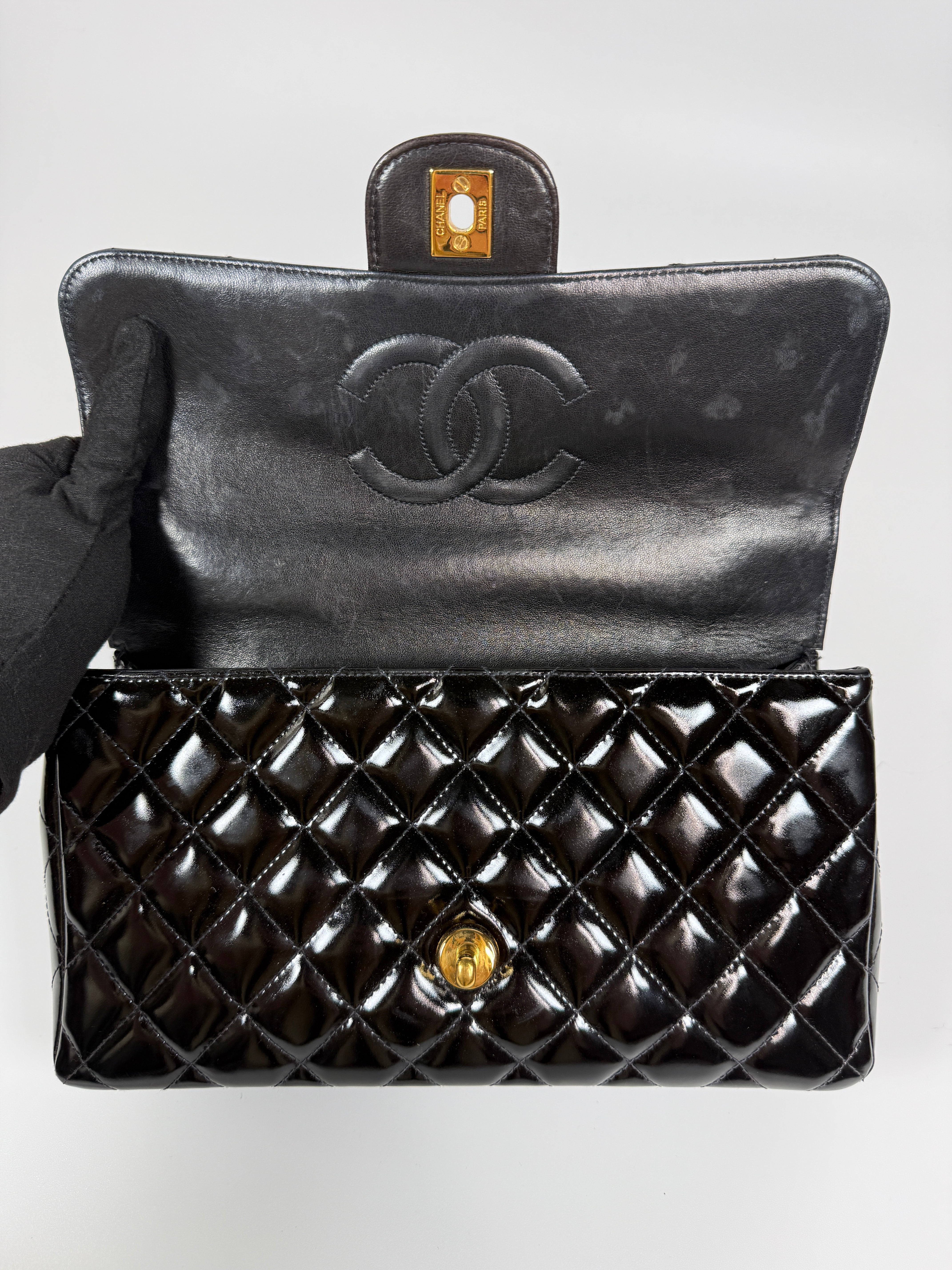 Authentic and preloved Chanel Vintage Kelly Top Handle Bag In Black Patent Leather With 24kt Gold Hardware. Very Good condition. 100% Authenticity guarantee 