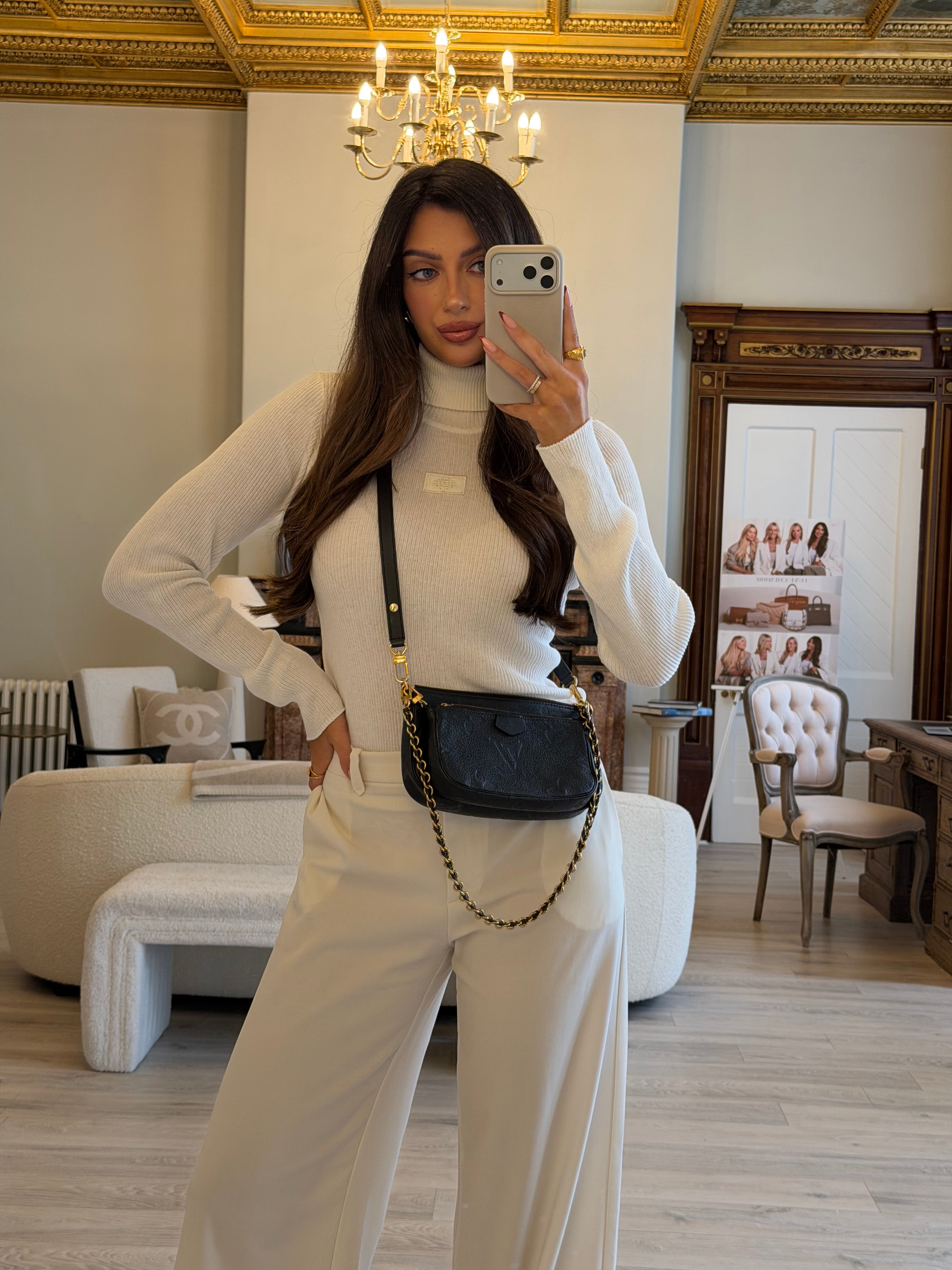 Woman taking a mirror selfie in a stylish room with decor elements.