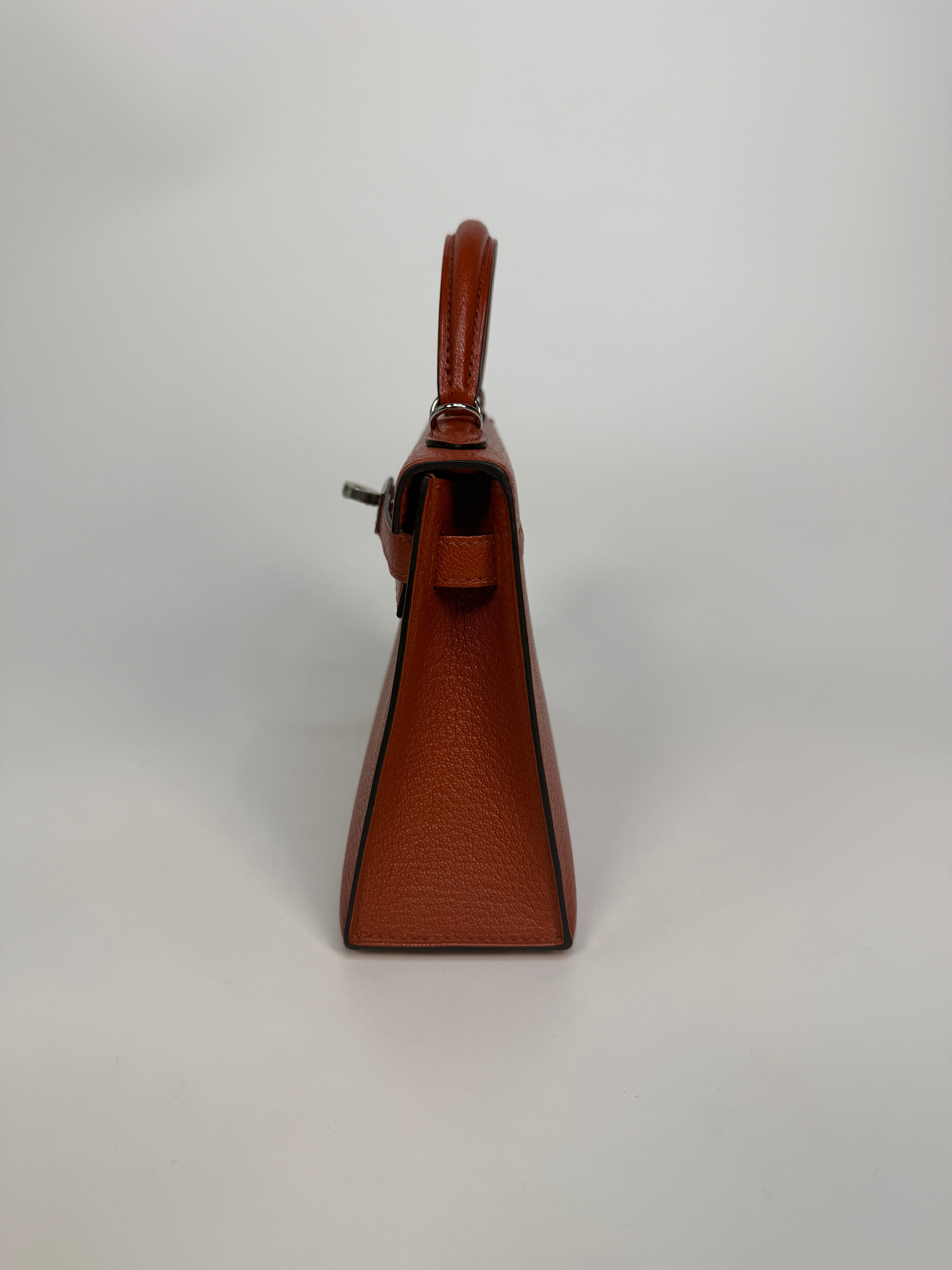 Hermès Mini Kelly In Cuivre Chèvre Mysore Leather With Palladium Hardware. Authentic and preloved in new and unused condition