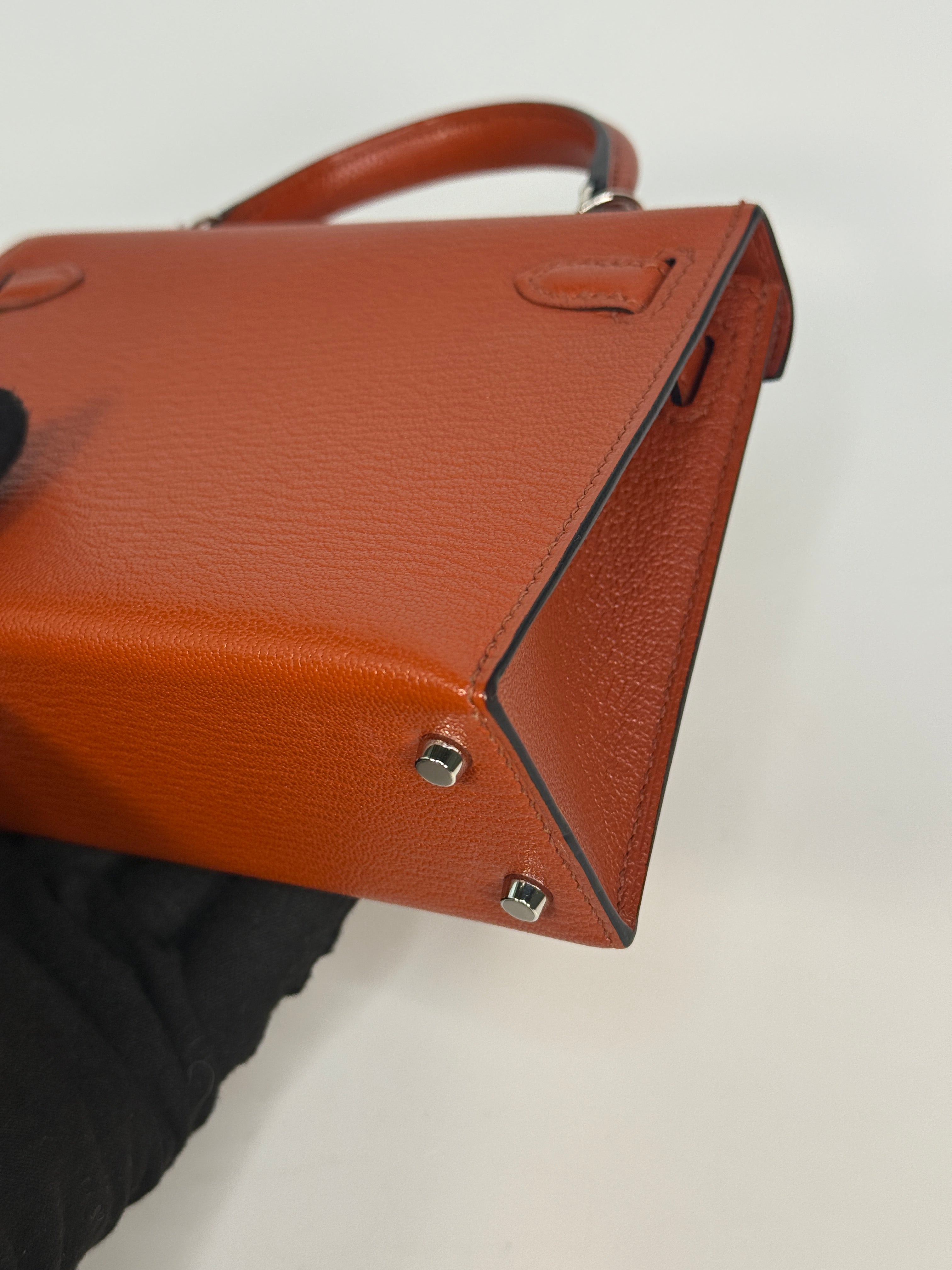 Hermès Mini Kelly In Cuivre Chèvre Mysore Leather With Palladium Hardware. Authentic and preloved in new and unused condition