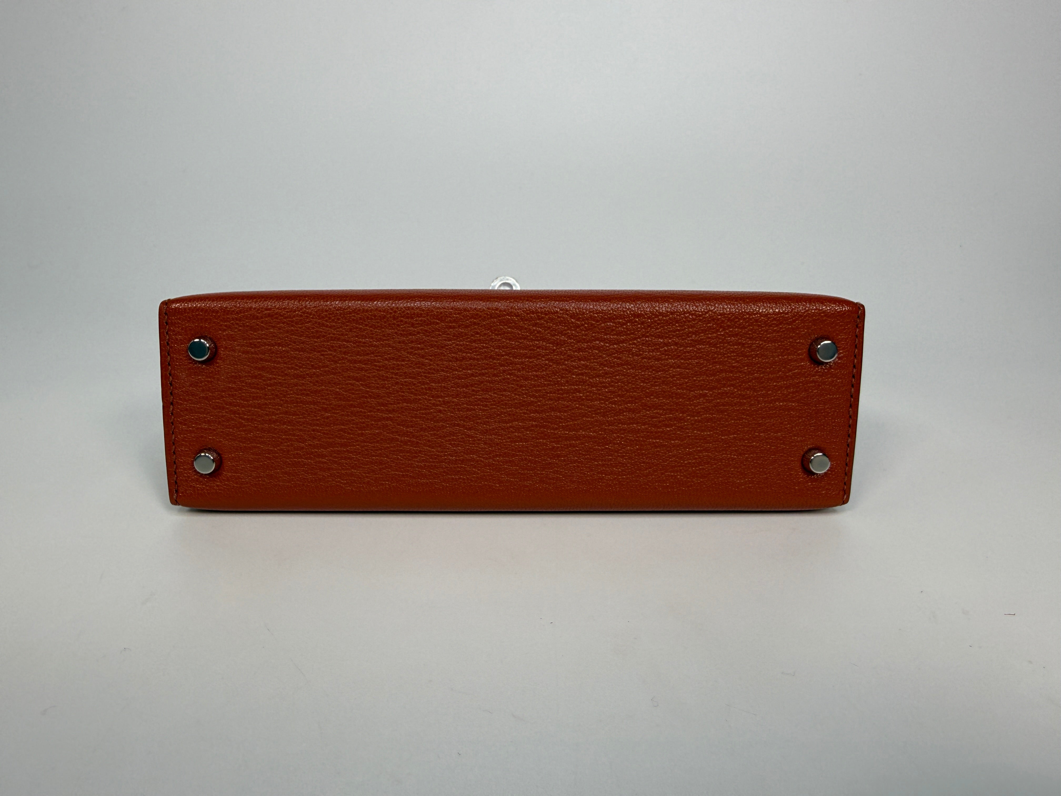 Hermès Mini Kelly In Cuivre Chèvre Mysore Leather With Palladium Hardware. Authentic and preloved in new and unused condition